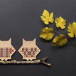 Two Moon Picnic plastic free wooden cross stitch owls on a small branch on a dark grey background