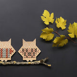 Two Moon Picnic plastic free wooden cross stitch owls on a small branch on a dark grey background