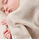 A close up of the MORI biscuit cellular blanket covering a baby showing the air hole detail for temperature control