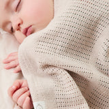 A close up of the MORI biscuit cellular blanket covering a baby showing the air hole detail for temperature control