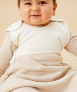  A baby inside the oatmeal sriped MORI sleeping bag showing the stripe detail on organic cotton fabric and popper fastener on the shoulder for easy fitting 