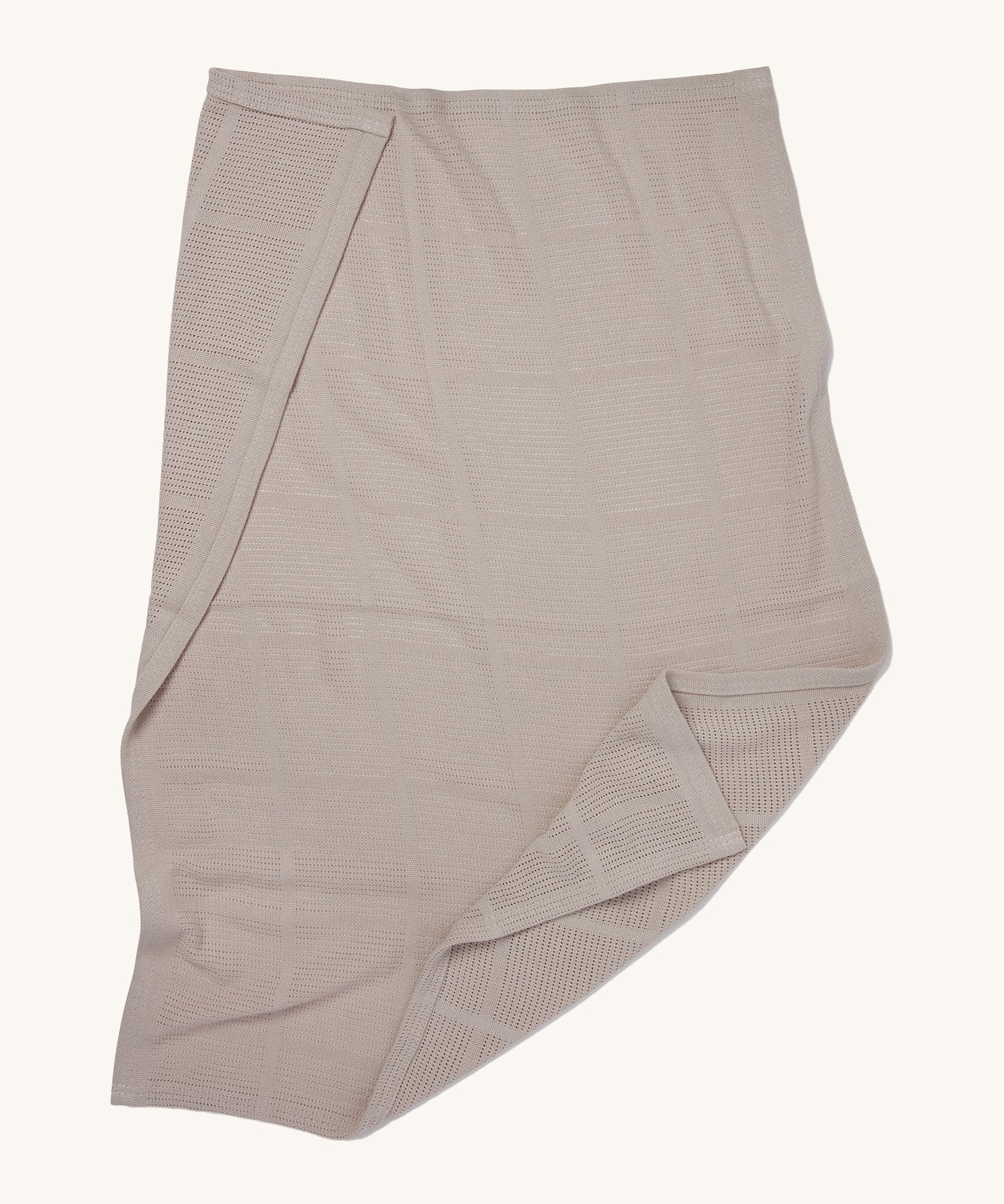 MORI cellular blanket in biscuit laid out showing the air hole detail on organic fabric. 