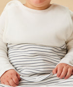 A closeup of A little baby wearing the Mori organic cotton clever sleeping bag 2.5 TOG, in a grey stripe design.
