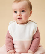 A little baby wearing the Mori organic cotton clever sleeping bag 1.5 TOG, in a blush stripe design.