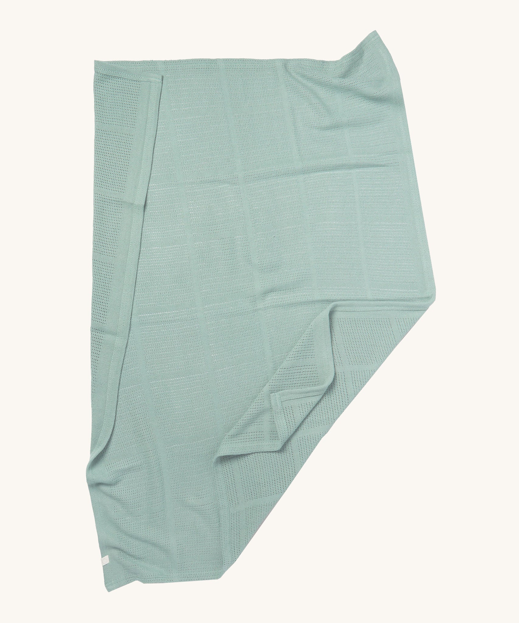 MORI cellular blanket in mint green laid out showing the air hole detail on organic fabric. 