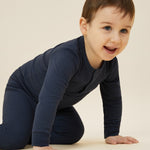 A close up of a toddler wearing the MORI ribbed style pyjama set in navy blue colour showing the popper detail on the top