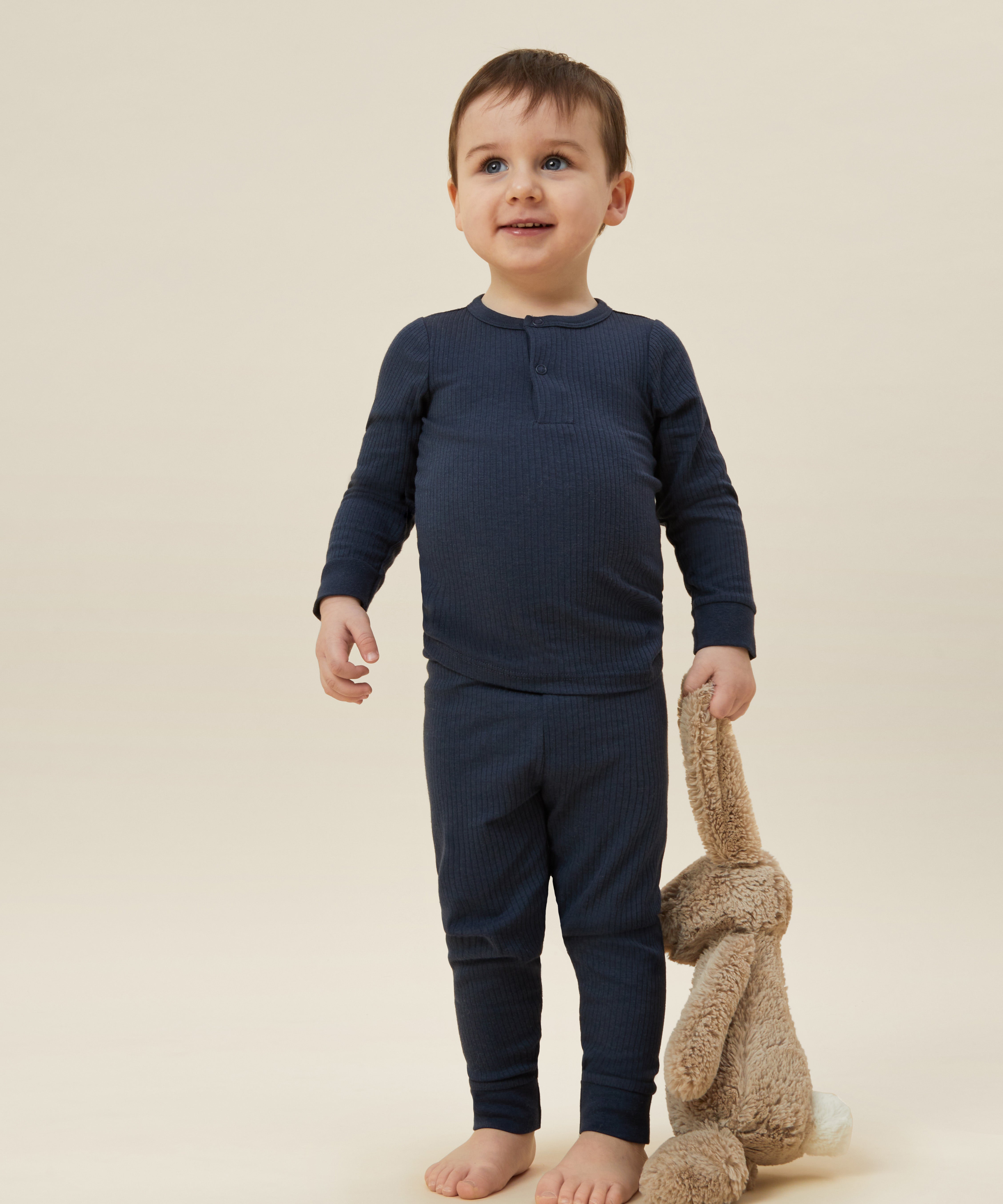 A toddler wearing the MORI ribbed style pyjama set in navy colour