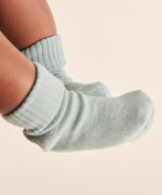 A closeup of a baby's feet, wearing light blue Mori organic cotton socks