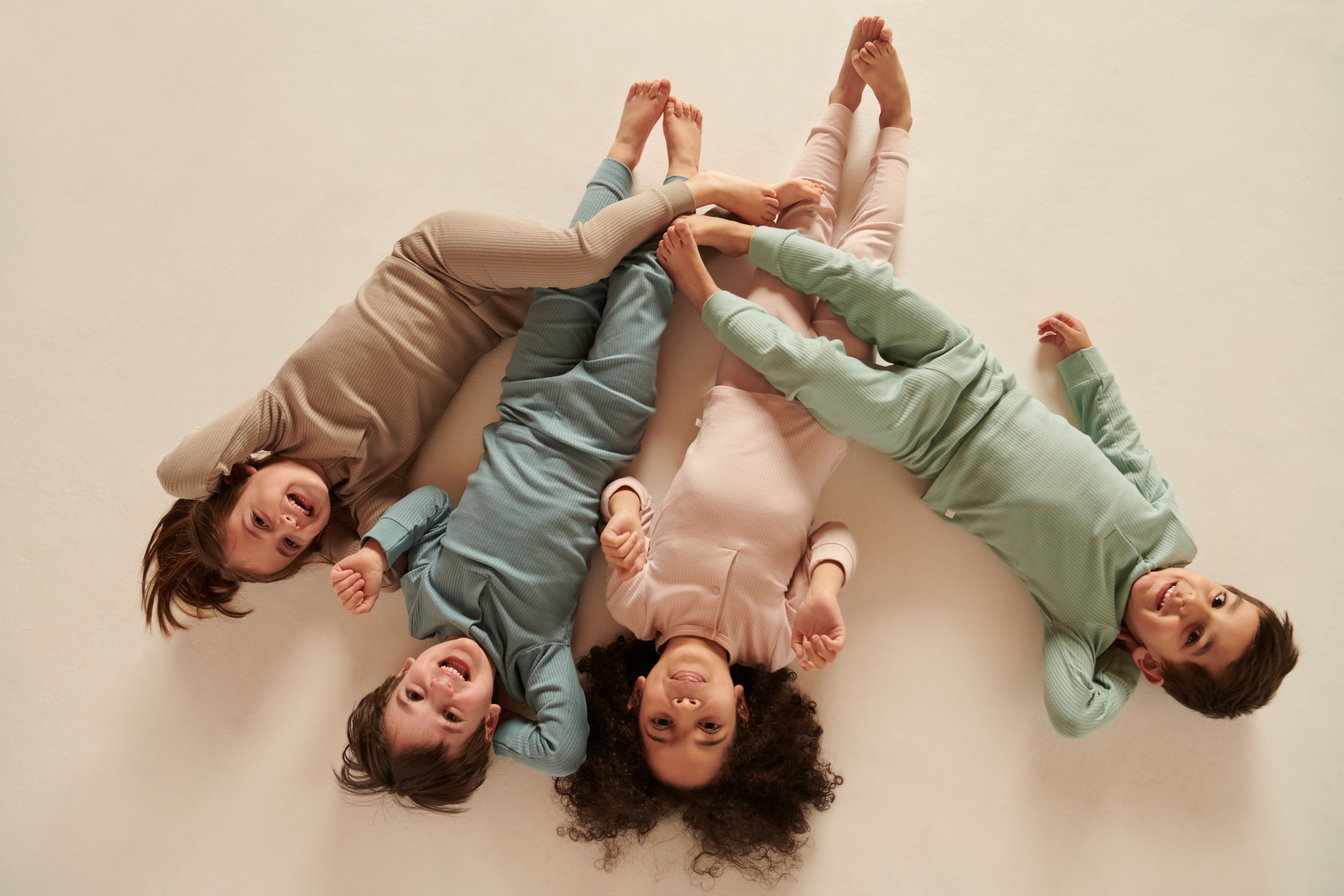 Four children wearing colour coordinating Mori ribbed outfits, including the comfy joggers