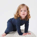 A toddler crawling and wearing the MORI ribbed style pyjama set in navy colour