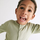 A close up of the MORI ribbed pyjama in sage green showing the popper fastener detail