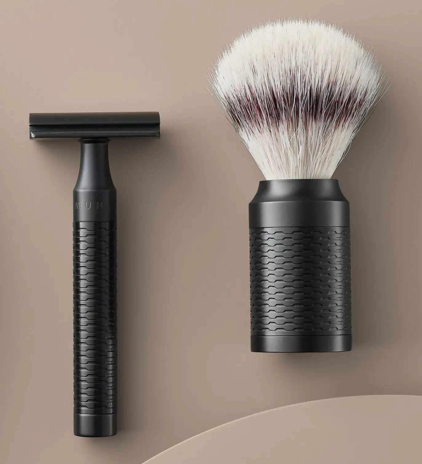 Muhle Rocca jet black stainless steel safety razor next to a maching shaving brush with silvertip synthetic fibres