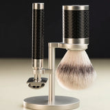 Muhle Rocca safety razor next to a maching shaving brush with silvertip synthetic fibres hanging on a stand