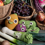Myum handmade soft crochet vegetable toys laid out on a table amongst real vegetables