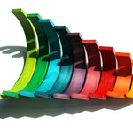 9 pieces of Naef's wooden rainbow toy scattered to make a chicken shaped figure on a white background