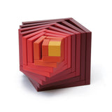 Naef's Cella cube in red twisted to make a swirling pattern from the different cube pieces. Cube is placed on a white background.