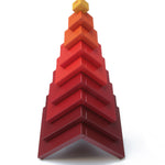 Naef's Cella cube toy stacked in a pyramid shape on a white background.
