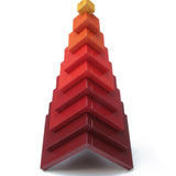 Naef's Cella cube toy stacked in a pyramid shape on a white background.