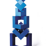 Blue Naef Cubicus stacked in a complex geometric tower on a white background.