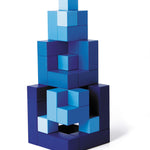 Blue Naef Cubicus stacked in a pyramid tower with smallest cube piece at the top. Tower is placed on a white background.