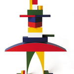 Naef Bauhaus building blocks stacked into a person shape on a white background