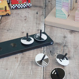 Naef monochrome optical illusion spinning tops loose on a wooden surface 