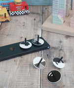 Naef monochrome optical illusion spinning tops loose on a wooden surface 
