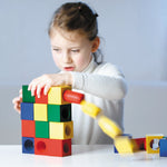 Pieces of the Naef Ligno wooden building blocks set stacked on a beige background