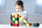 Pieces of the Naef Ligno wooden building blocks set stacked on a beige background