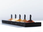 Close up of the the 5 Naef premium wooden spinning tops toy set on a white background