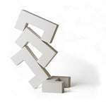 4 white Naef Quadrigo pieces stacked on one another to make a tower on a white background.
