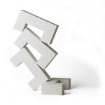 4 white Naef Quadrigo pieces stacked on one another to make a tower on a white background.