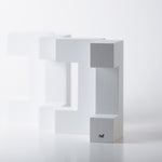 4 pieces of Naef's Quadrigo toy  lined up on end to make a diagonal row on a white background.