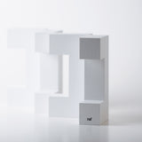 4 pieces of Naef's Quadrigo toy  lined up on end to make a diagonal row on a white background.