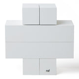 4 identical pieces of Naef's Quadrigo wooden toy slotted together to make a cross shape on a white background.