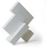4 pieces of Naef's Quadrigo toy assembled to make a geometric shape titled diagonally.