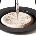 A closeup of the precise and satisfying geometric patterns created in the sand of the Naef Sand Pendulum.