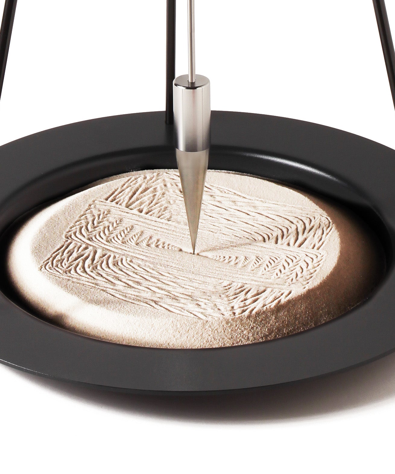 A closeup of the precise and satisfying geometric patterns created in the sand of the Naef Sand Pendulum.