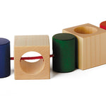Naef Signa wooden threading toy positioned in a line on a white background. Shows thread woven through all 4 cubes and 4 cyclinders.