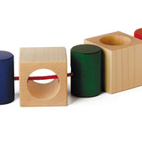 Naef Signa wooden threading toy positioned in a line on a white background. Shows thread woven through all 4 cubes and 4 cyclinders.