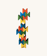 Vertical tower made from colourful Naef Spiel Mini interlocking wooden cubes. Premium German made desk toy and geometric wooden puzzle.
