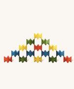 Pyramid-like creation built with Naef Spiel Mini precision wooden blocks in red, blue, green, and yellow. Elegant German made stacking game and design object.