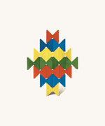 Colourful geometric structure built from Naef Spiel Mini precision wooden blocks in red, blue, yellow, and green. Modern German made wooden puzzle and desk toy.