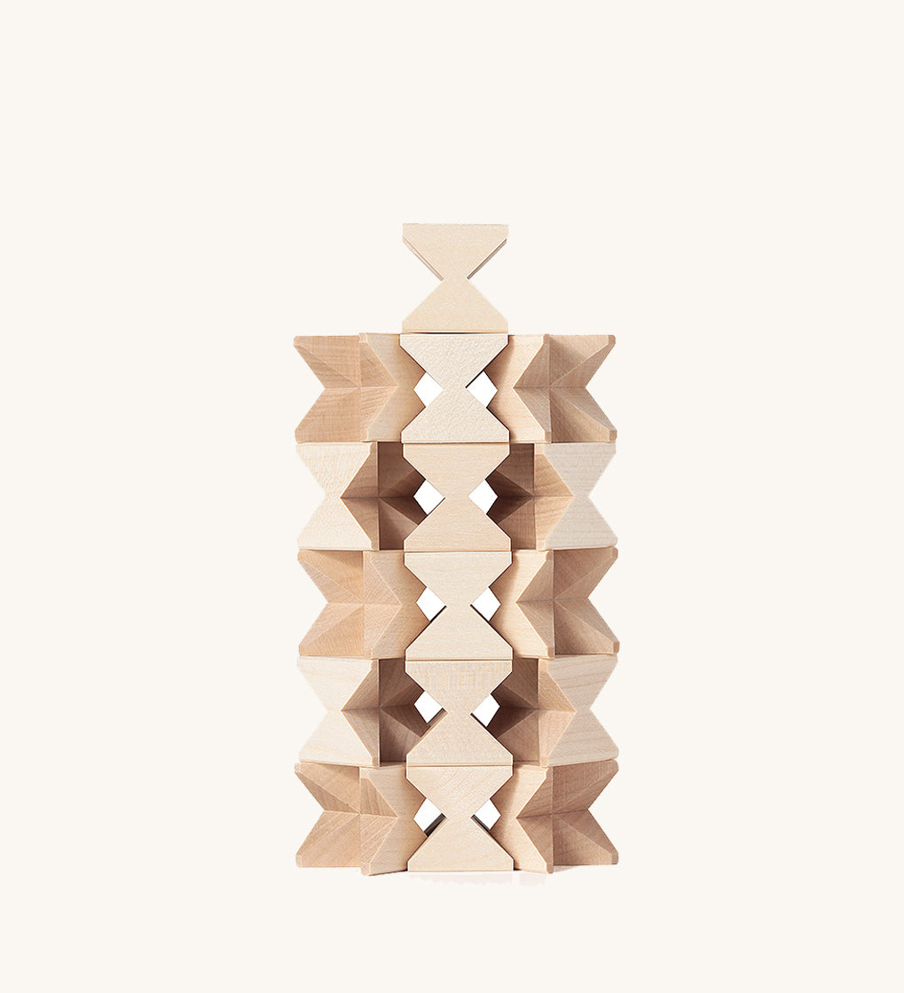 The Naef Mini Spiel in natural, made in Germany and designed in Switzerland, stacked in a complex tower