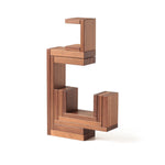 The Naef Corus walnut wood stacking toy, stacked on top of the cubic keystone to create a mesmerising geometric sculpture.