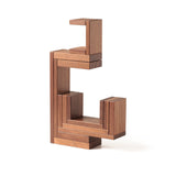 The Naef Corus walnut wood stacking toy, stacked on top of the cubic keystone to create a mesmerising geometric sculpture.