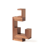 The Naef Corus walnut wood stacking toy, stacked on top of the cubic keystone to create a mesmerising geometric sculpture.