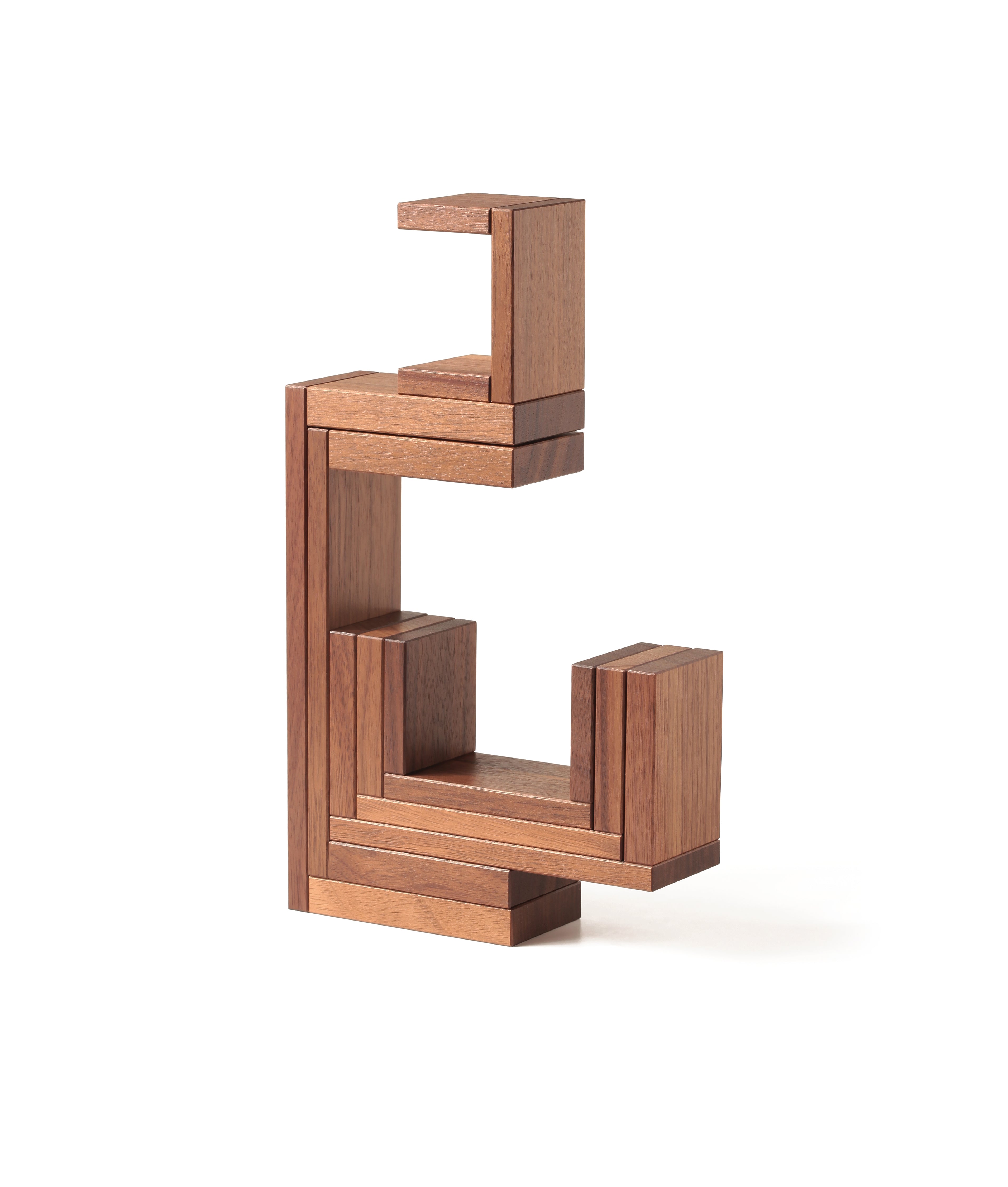 The Naef Corus walnut wood stacking toy, stacked on top of the cubic keystone to create a mesmerising geometric sculpture.