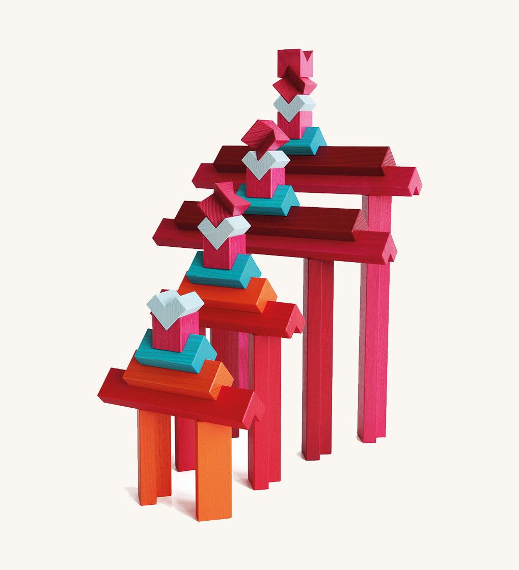 Layered tower of Naef Tigno coloured wooden blocks in varying lengths and hues. High quality German made precision wooden toy for stacking and display.