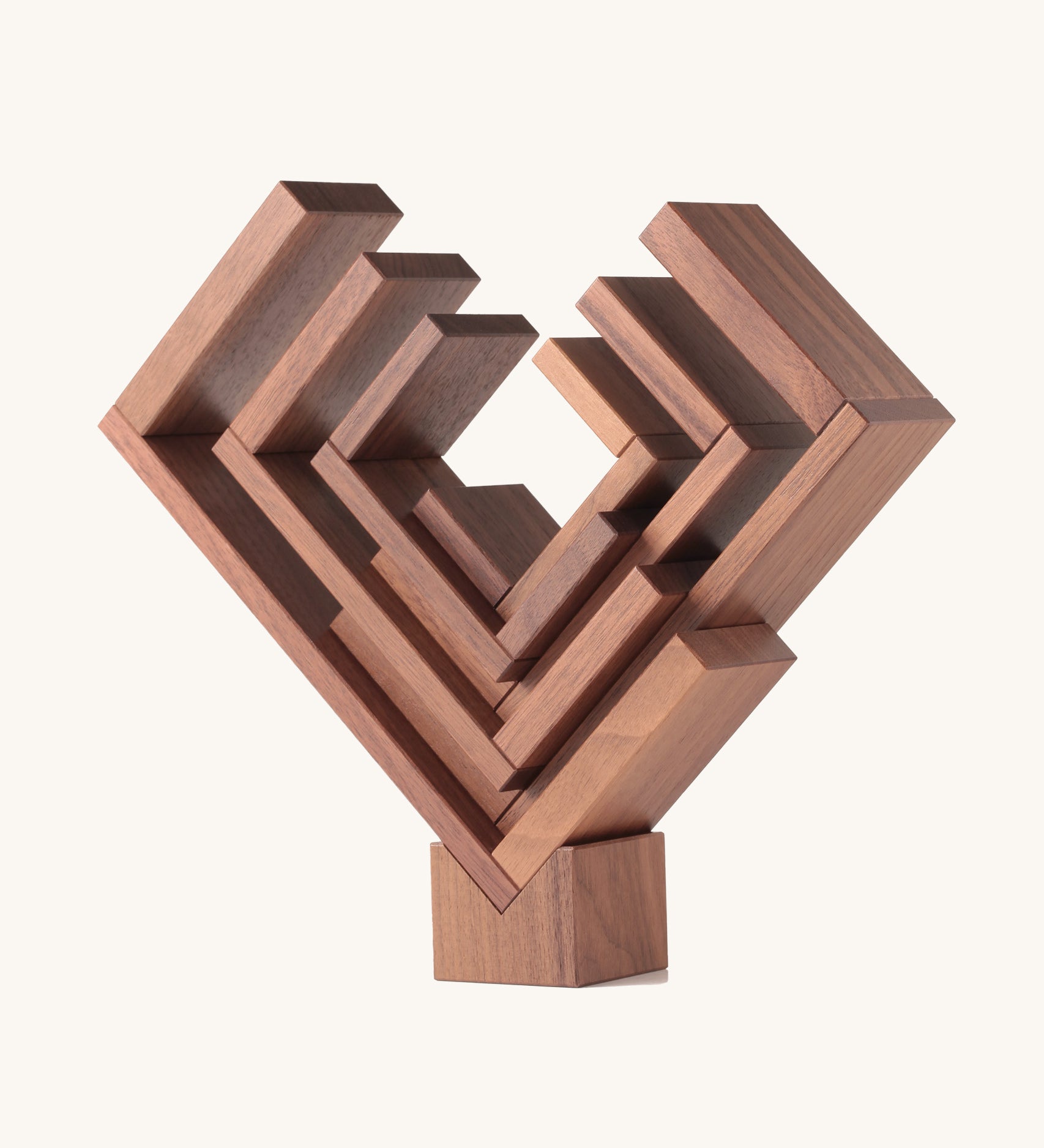 The Naef Corus walnut wood stacking toy, stacked on top of the cubic keystone to create a mesmerising geometric sculpture.
